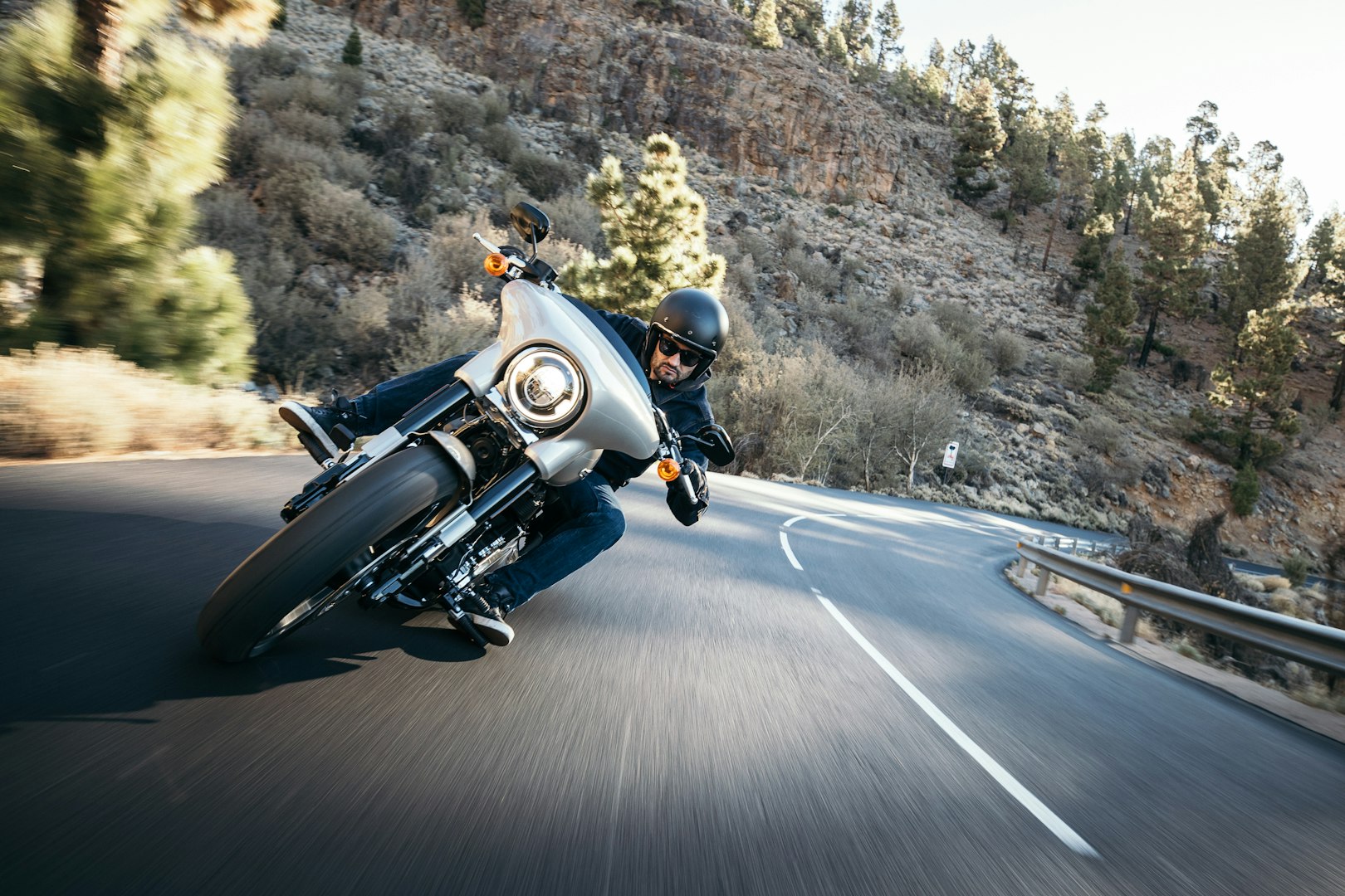 man on a custom classic motorcycle rides down the road, road traffic
